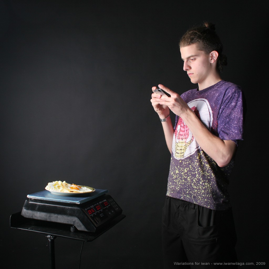 taking food photo - by Iwan Wilaga iwan is taking a digital picture of a meal, he tend to eat up from a digital weight scale.